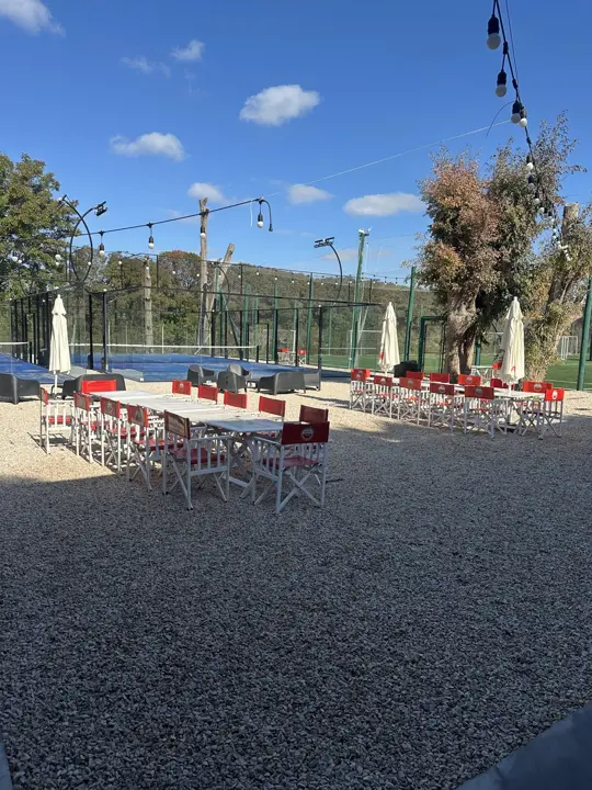 Patio con mesas largas y guirnaldas