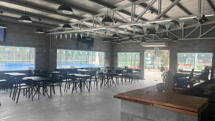Salón con mesas y vista a las canchas