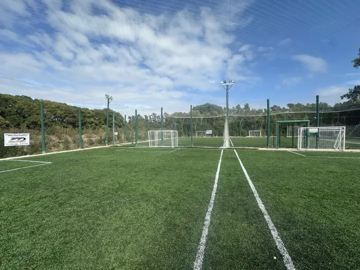 Cancha de fútbol de césped sintético con cielo despejado