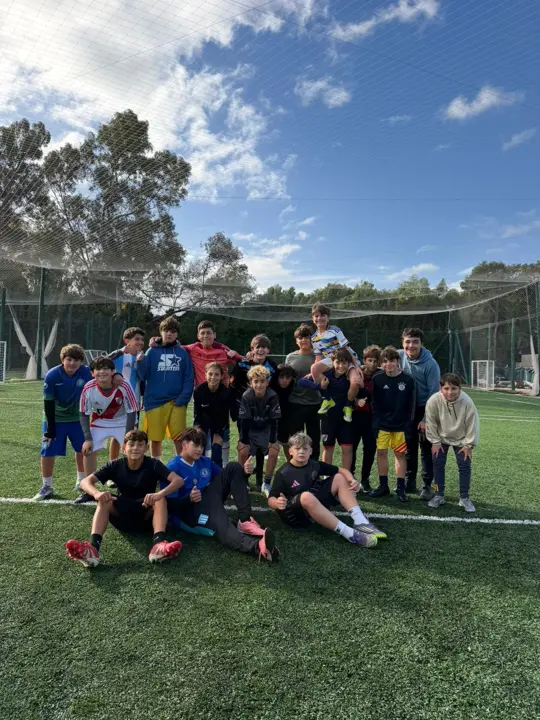 Equipo de chicos posando en la cancha de fútbol