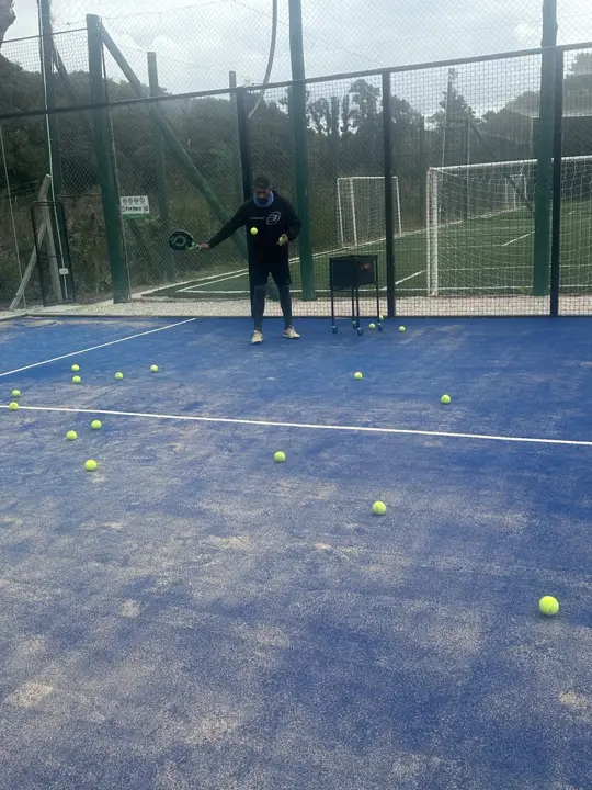 Clase de pádel con el profe lanzando pelotas