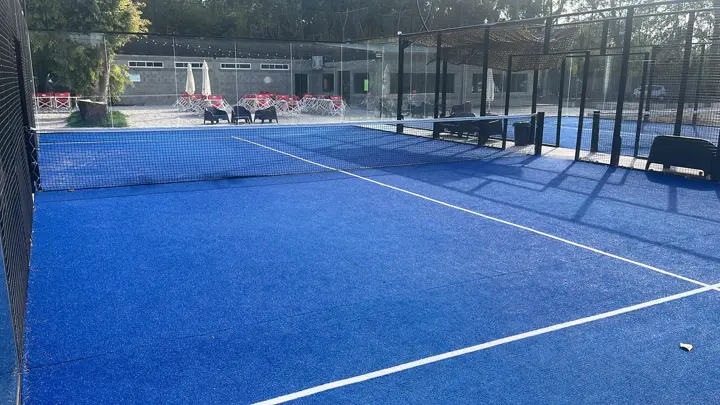Cancha de pádel azul vista desde la red