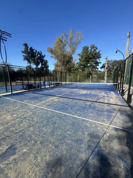 Cancha de pádel vacía con sol de la mañana