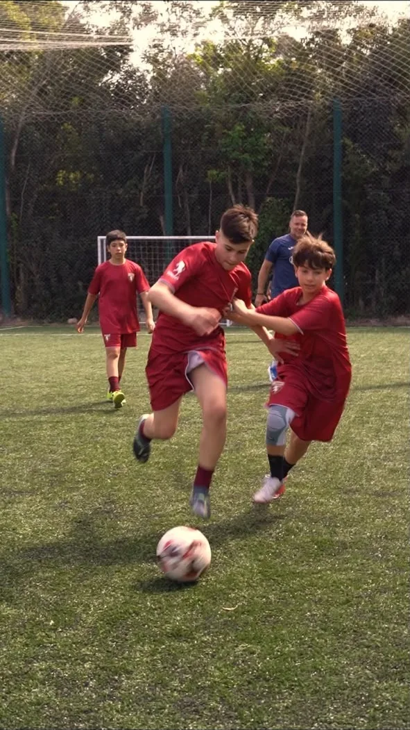 Chicos de la academia disputando una pelota en el entrenamiento